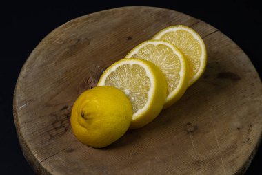 Koyu bir arka planda limon. Ahşap arka planda dilimlenmiş limon. Limonun yaratıcı fotoğrafı.