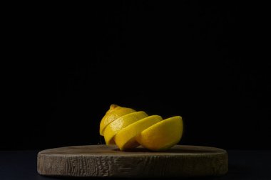 Koyu bir arka planda limon. Siyah arka planda dilimlenmiş limon. Limonun yaratıcı fotoğrafı.