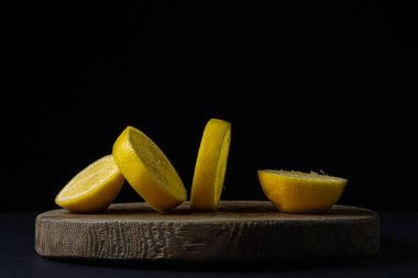 Koyu bir arka planda limon. Siyah arka planda dilimlenmiş limon. Limonun yaratıcı fotoğrafı.