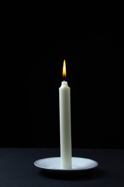 Siyah arka planda yanan mum. Karanlık arka planda yanan mumlar. Biraz ışık.