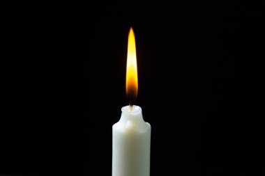 Siyah arka planda yanan mum. Karanlık arka planda yanan mumlar. Biraz ışık.