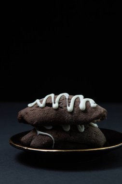 Koyu arkaplanda çikolata parçalı kurabiyeler. Siyah arka planda tatlılık. Yazıt ya da logo için bir yer var.
