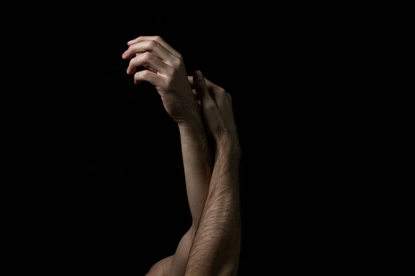 Male hands on a black background. Two male hands on a dark background. Body parts.