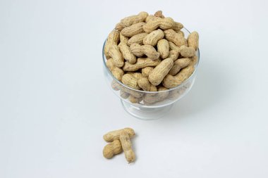 Beyaz arka planda yer fıstıkları. Hafif arka planda fıstıklı cam. Bira çerezi.