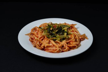 Arka planda domates soslu spagetti. Siyah arka planda sebze soslu spagetti. İtalyan yemeği. Lezzetli yemek.