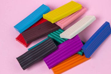 Pembe arka planda çok renkli plastikler. Eğitici bir oyun. Plastik set