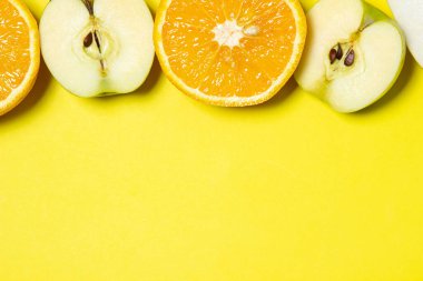 Sarı arka planda dilimlenmiş meyveler. Sağlıklı beslenme. Meyve temalı, bir yazı ve logo için bir yer var.