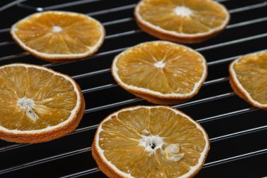 Dried orange slices on a black background. Dried orange on a dark background. Dried fruit.