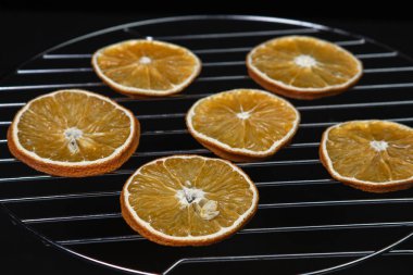 Dried orange slices on a black background. Dried orange on a dark background. Dried fruit.