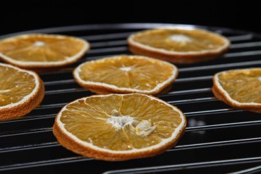 Dried orange slices on a black background. Dried orange on a dark background. Dried fruit.