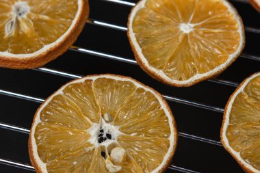 Dried orange slices on a black background. Dried orange on a dark background. Dried fruit.
