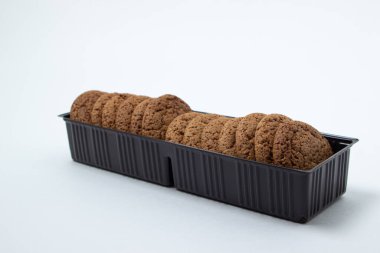 Beyaz arka planda plastik bir kapta yulaflı kurabiyeler. Diyet yemek. Hafif kahvaltı.