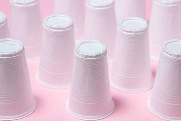 粉色背景的塑料眼镜 可处置的餐具 塑料制品 — 图库照片