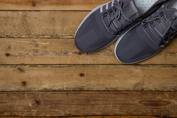 Ahşap arka planda gri spor ayakkabılar. Spor ayakkabılar. Sağlıklı yaşam tarzı kavramı