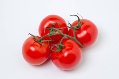 Beyaz arka planda sarmaşık domatesleri. Taze ve sağlıklı sebzeler. Olgun ve sulu domates