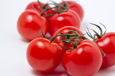 Beyaz arka planda sarmaşık domatesleri. Taze ve sağlıklı sebzeler. Olgun ve sulu domates