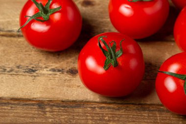 Ahşap arka planda domatesler. Olgun ve taze domatesler. Sağlıklı sebzeler.