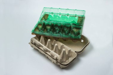 Beyaz arka planda yumurtalar için plastik ve kağıt kaplar. Tavuk yumurtası depolamak için konteyner..