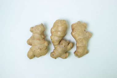 Beyaz arka planda zencefil. Zencefil kökü. Üç zencefil yan yana yatar.