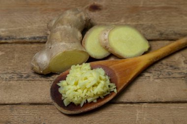 Ahşap arka planda zencefil. Zencefil kökü doğranmış. Sağlıklı yiyecekler. Sağlıklı gıda konsepti