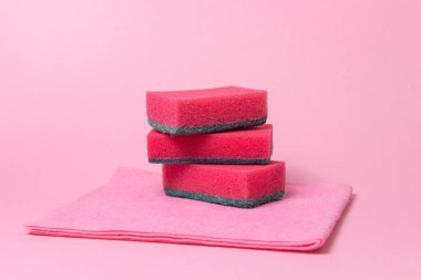 Pembe arka planda temizlik aletleri. Ev temizlik aletleri. Bulaşık süngeri..