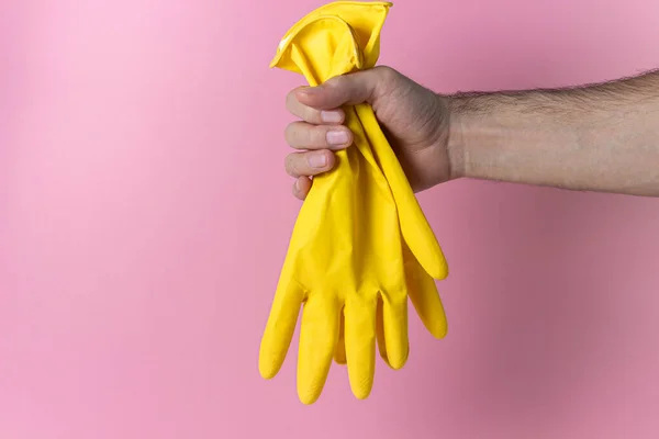 Hand Hält Gummihandschuhe Auf Rosa Hintergrund Reinigungswerkzeuge Auf Farbigem Hintergrund — Stockfoto