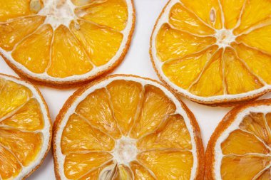 Beyaz arka planda kurutulmuş turuncu. Yuvarlak kurumuş portakal dilimleri. Hafif arkaplanda kurumuş meyve