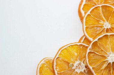 Beyaz arka planda kurutulmuş turuncu. Yuvarlak kurumuş portakal dilimleri. Hafif arkaplanda kurumuş meyve