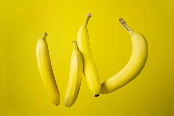 黄色背景的香蕉 亮晶晶的水果彩色背景的四只香蕉 — 图库照片