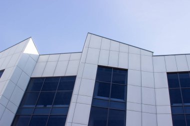 Gökyüzüne karşı modern ofis binası. Bir iş binasının cephesi. Ofis pencereleri.