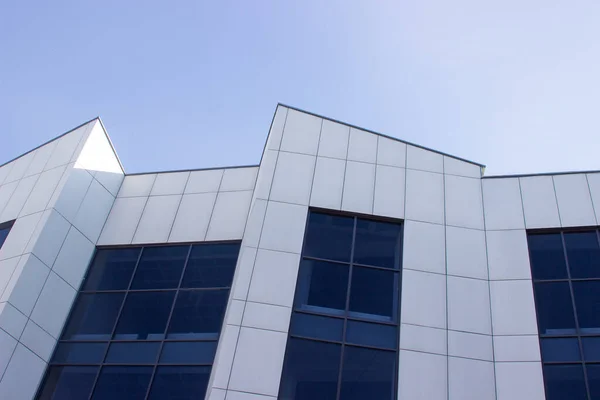 Gökyüzüne karşı modern ofis binası. Bir iş binasının cephesi. Ofis pencereleri.