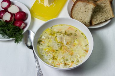 Beyaz masa örtüsü üzerinde ev yapımı pirinç çorbası. Besleyici bir öğle yemeği. Sağlıklı beslenme kavramı