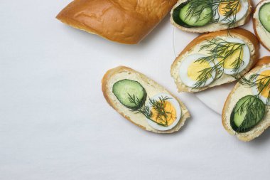 Beyaz masa örtüsü üzerinde sandviçler. Bir şeyler atıştır. Kahvaltı için lezzetli ve hafif sandviçler.