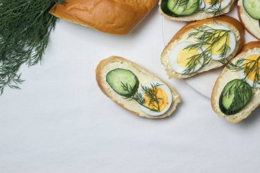 Beyaz masa örtüsü üzerinde sandviçler. Bir şeyler atıştır. Kahvaltı için lezzetli ve hafif sandviçler.