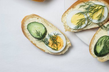 Beyaz masa örtüsü üzerinde sandviçler. Bir şeyler atıştır. Kahvaltı için lezzetli ve hafif sandviçler.