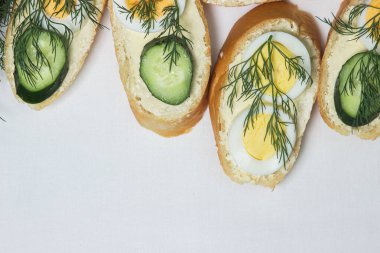 Beyaz masa örtüsü üzerinde sandviçler. Bir şeyler atıştır. Kahvaltı için lezzetli ve hafif sandviçler.