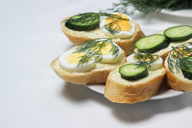 Beyaz masa örtüsü üzerinde sandviçler. Bir şeyler atıştır. Kahvaltı için lezzetli ve hafif sandviçler.