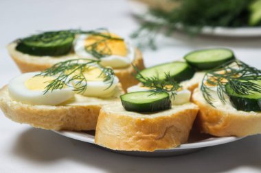 Beyaz masa örtüsü üzerinde sandviçler. Bir şeyler atıştır. Kahvaltı için lezzetli ve hafif sandviçler.