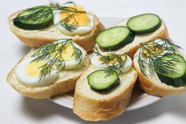 Beyaz masa örtüsü üzerinde sandviçler. Bir şeyler atıştır. Kahvaltı için lezzetli ve hafif sandviçler.