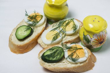 Beyaz masa örtüsü üzerinde sandviçler. Bir şeyler atıştır. Kahvaltı için lezzetli ve hafif sandviçler.