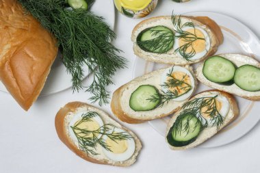 Beyaz masa örtüsü üzerinde sandviçler. Bir şeyler atıştır. Kahvaltı için lezzetli ve hafif sandviçler.