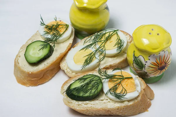 Beyaz masa örtüsü üzerinde sandviçler. Bir şeyler atıştır. Kahvaltı için lezzetli ve hafif sandviçler.