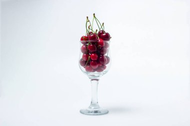 Beyaz arka planda kırmızı kirazlar. Kuyruklu kiraz tatlısı. Sağlıklı yemek.