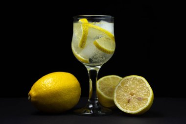 Siyah arka planda buzlu ve limonlu kokteyl. Alkolsüz kokteyl..
