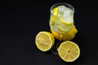 Siyah arka planda buzlu ve limonlu kokteyl. Alkolsüz kokteyl..