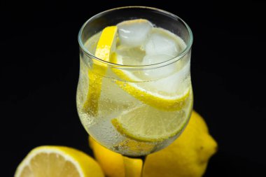 Siyah arka planda buzlu ve limonlu kokteyl. Alkolsüz kokteyl..