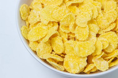 Beyaz arka planda mısır gevreği tabağı. Sağlıklı ve lezzetli bir kahvaltı..