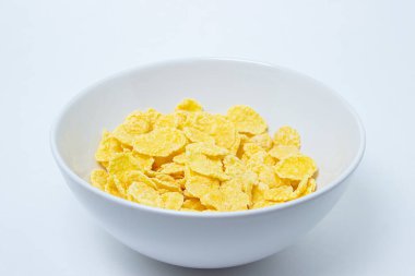 Beyaz arka planda mısır gevreği tabağı. Sağlıklı ve lezzetli bir kahvaltı..