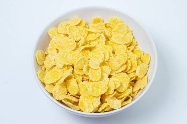 Beyaz arka planda mısır gevreği tabağı. Sağlıklı ve lezzetli bir kahvaltı..