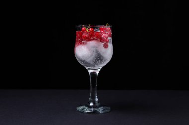 Siyah arka planda kırmızı üzümlü ve buzlu kokteyl. Alkolsüz kokteyl..